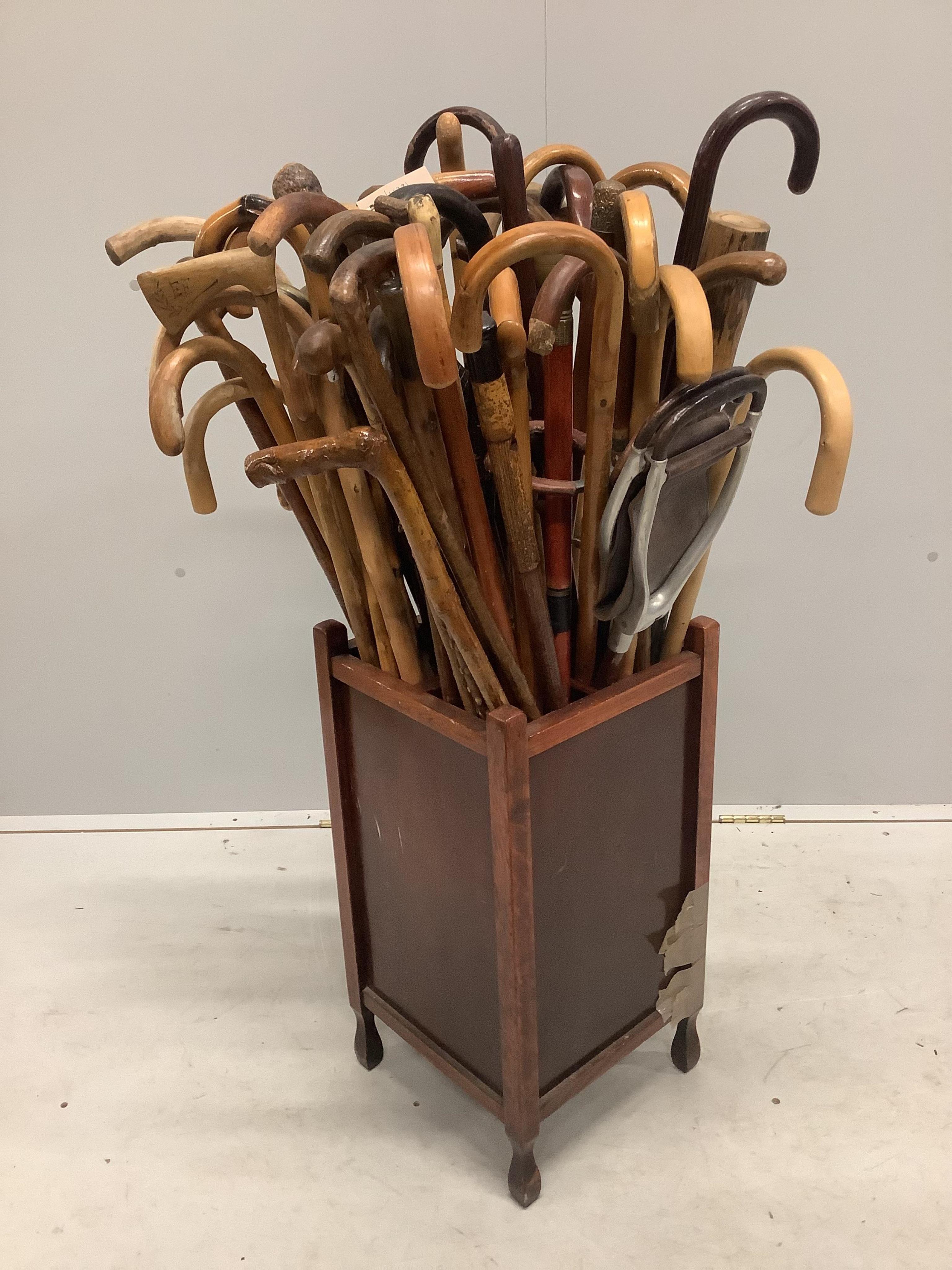 A large collection of assorted walking and shooting sticks in four division stick stand. Condition - fair, stand poor